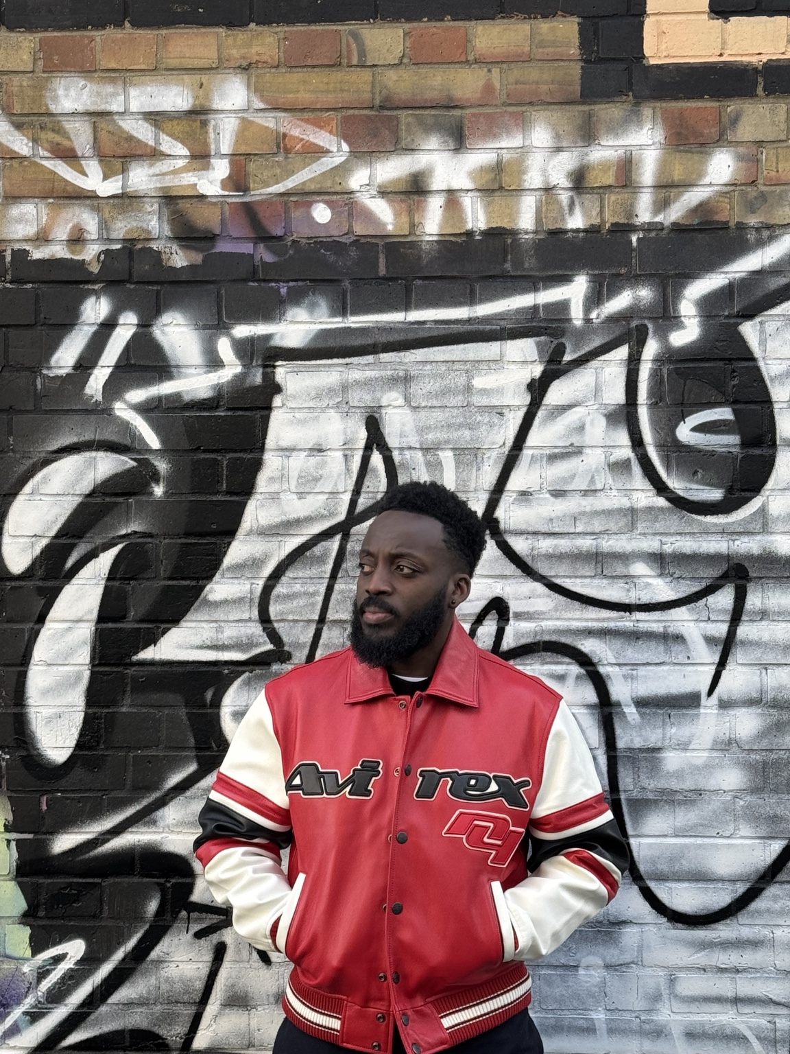 Coach Ray Sefah in front of a graffiti wall