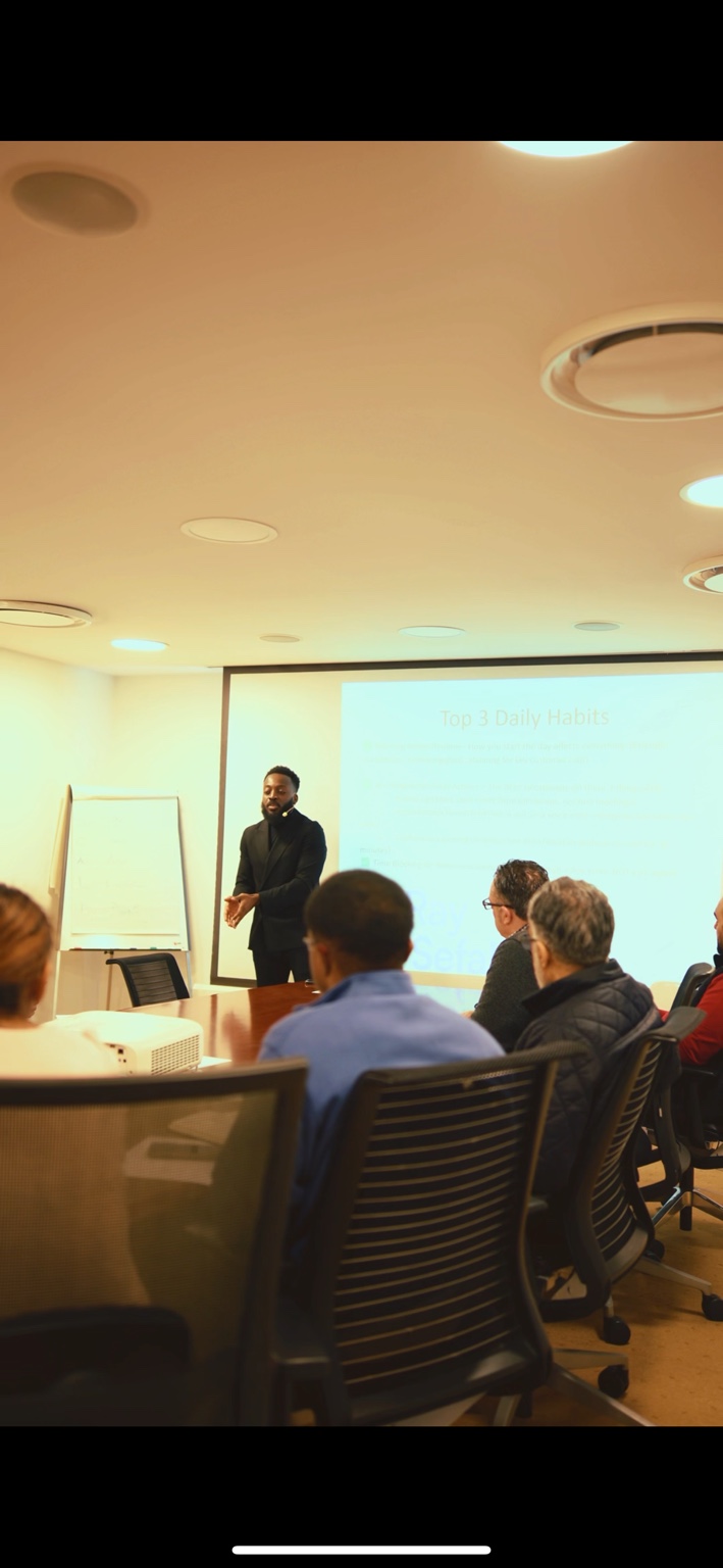 Coach Ray Sefah speaking to a group in a business meeting room